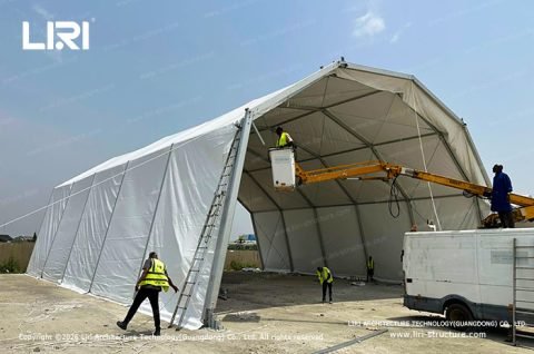 Eyelid Hangar Tent installation crew using aerial lift on site