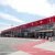 Large exhibition hall tent exterior with flagpoles and red carpet entrance