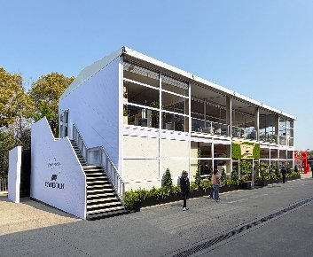 Two story tent F1 Paddock Club exterior with white PADDOCK branded stair wall