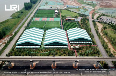Aerial view of modular sports halls beside football pitches