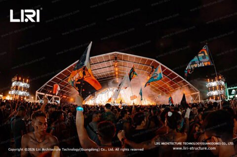 Flag waving crowd in front of a polygon top event tent