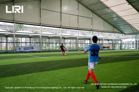Football players training inside modular sports hall