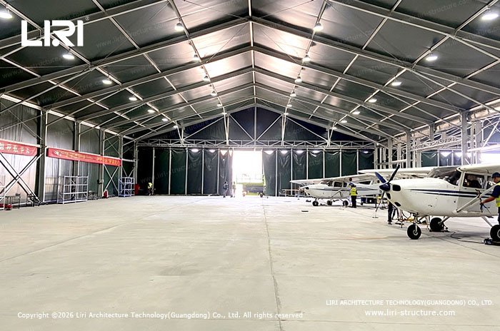 Spacious modular aircraft hangar interior with light aircraft and clear span structure