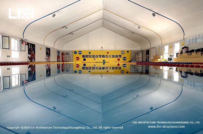 Covered swimming pool protected beneath a bright insulated tent roof