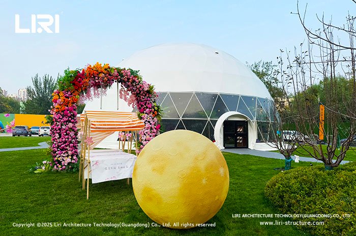 Geodesic dome tent at an outdoor brand pop-up event with a floral entrance