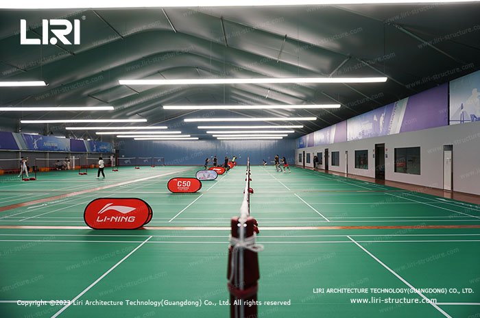 Spacious indoor badminton training hall with multiple courts and high clearance