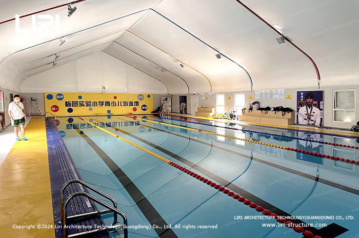 Swimming lanes inside an enclosed pool tent with shaded roof coverage