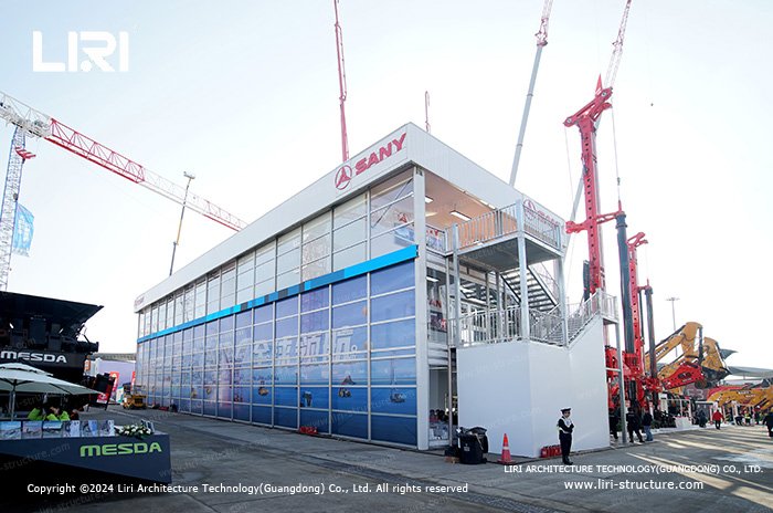 Three-storey modular event building with external stairs and an upper terrace