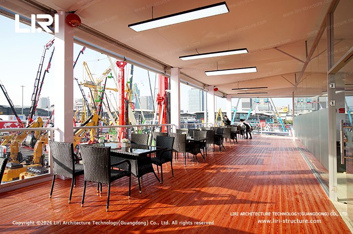 Upper-floor hospitality lounge with panoramic views in a triple decker structure