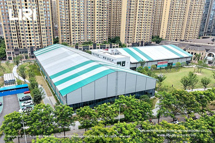 Sports tent buildings surrounded by lawns, trees and residential towers